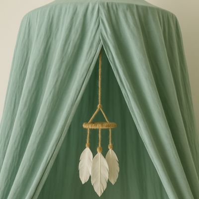 Zoom tissu ciel de lit bébé vert avec déco plume