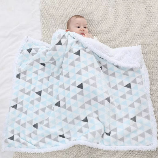 Bébé allongé sur la couverture motif géométrique