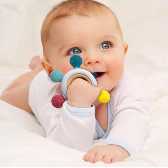 Bébé jouant avec son hochet multi-sensoriel, développant sa motricité