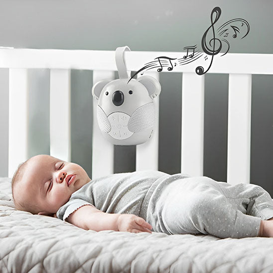 Machine bruit blanc accrochée au lit de bébé