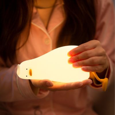Personne tenant la veilleuse Lazy Duck, émettant une douce lumière dans la nuit