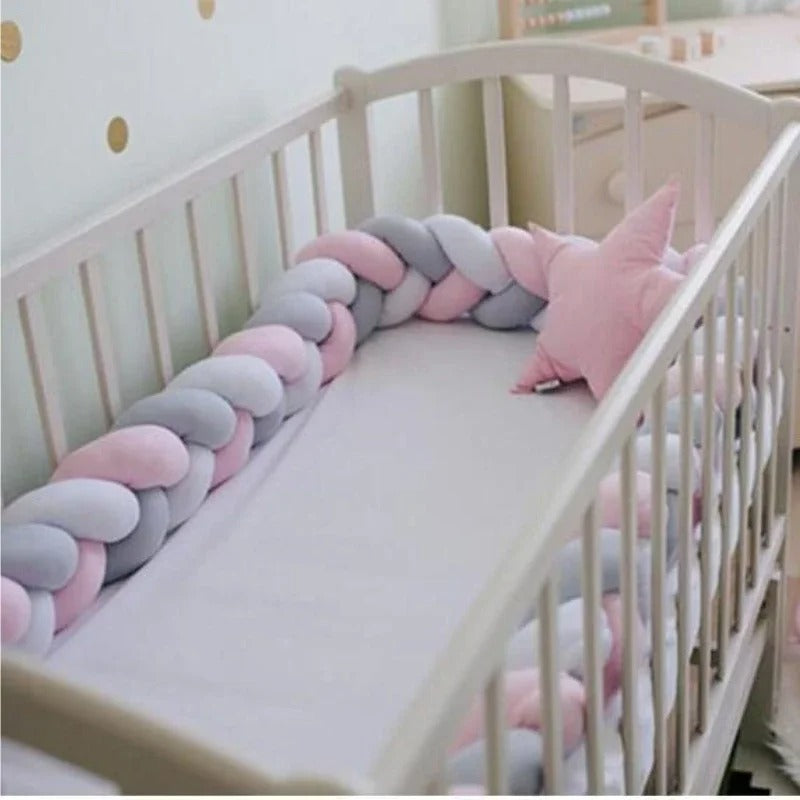 Tour de lit tressé rose et gris clair dans lit bébé avec coussin étoile assorti
