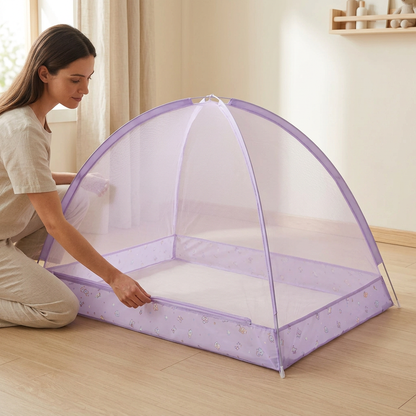 Une maman ajuste la bordure de la moustiquaire lit bébé Cocon Violet déployée dans une chambre lumineuse