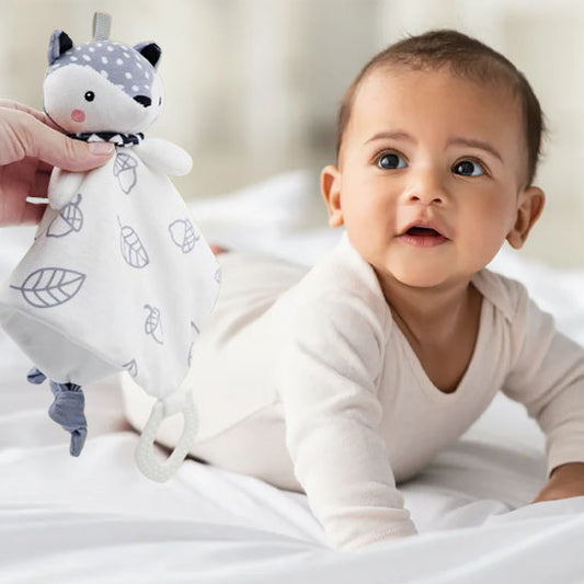 Bébé souriant avec un doudou renard lapin gris