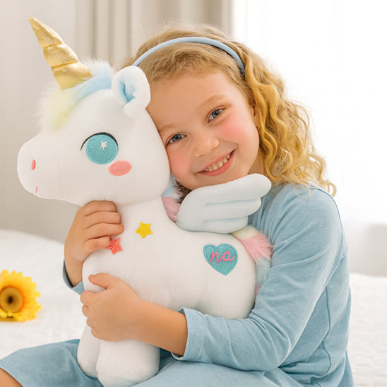 enfant sourit avec peluche licorne magique