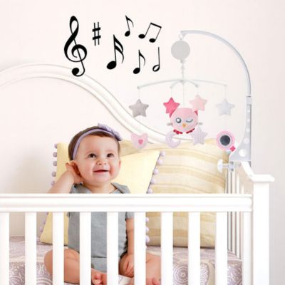 Bébé joue avec un mobile musical au berceau