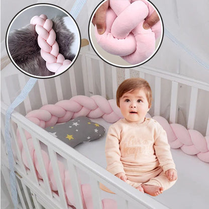 Tour de lit tressé rose pastel avec zoom sur le rembourrage et bébé assis