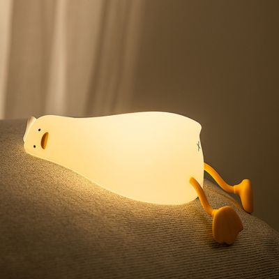Veilleuse Lazy Duck allongée sur un canapé, apportant une lumière douce et réconfortante