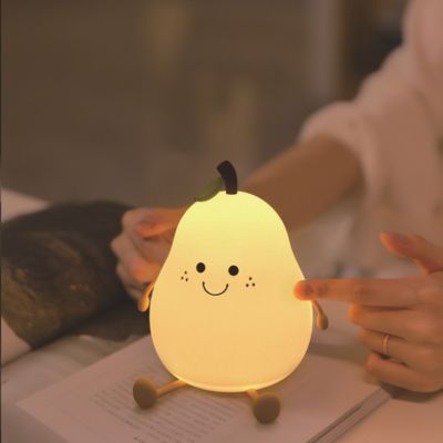 Veilleuse en forme de poire assise sur un support, ambiance douce et ludique